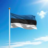 agitant drapeau de Estonie sur mât avec ciel Contexte. photo