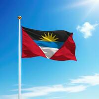 agitant drapeau de antigua et Barbuda sur mât avec ciel Contexte. photo