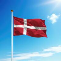 agitant drapeau de Danemark sur mât avec ciel Contexte. photo