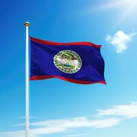 agitant drapeau de Belize sur mât avec ciel Contexte. photo