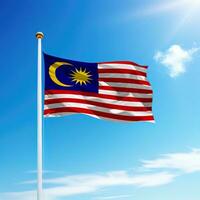 agitant drapeau de Malaisie sur mât avec ciel Contexte. photo