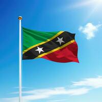 agitant drapeau de Saint kitts et nevis sur mât avec ciel Contexte. photo