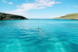 une bienheureux nager dans une parfait bleu lagune photo