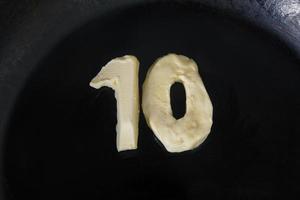 beurre en forme de numéro 10 sur une poêle chaude - vue de dessus en gros plan photo