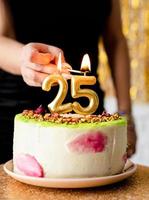 femme allumant des bougies sur un gâteau d'anniversaire photo