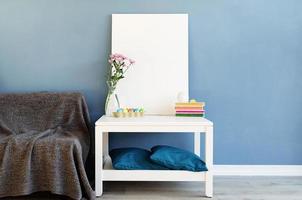 maquette de cadre d'affiche blanc sur une table basse dans une chambre bleue photo