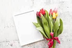 bouquet de tulipes et cadre vierge pour la conception de maquettes sur fond blanc photo