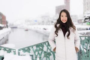 femme asiatique souriante heureuse de voyager dans la neige hiver photo