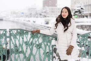 femme asiatique souriante heureuse de voyager dans la neige hiver photo