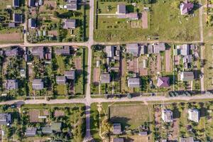 panoramique aérien vue de éco village avec en bois Maisons, gravier route, jardins et vergers photo