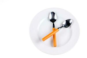 deux cuillères avec Orange poignées sur une blanc assiette photo