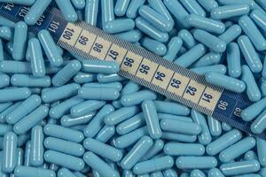 bleu poids perte pilules et mesure ruban symbolisant minceur photo