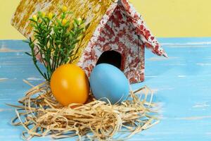 coloré des œufs symbolisant Pâques, avec une jouet loger, fleurs comme une jardin photo