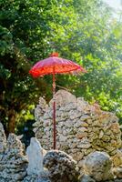 traditionnel balinais parapluie et Roche mur sur le plage de Kuta bali photo