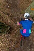 homme équitation une Montagne bicyclette par une boisé zone sur été journée. photo