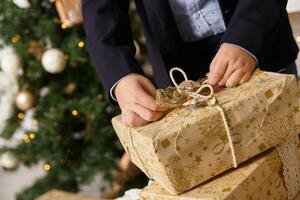 mains de garçon ouvre une boîte avec Noël cadeau photo