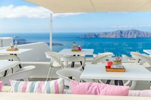 café sur le terrasse surplombant le mer. Santorin île, Grèce. superbe été humeur, Extérieur restaurant. romantique vibrations, été couleurs en dessous de blanc tente et bleu ciel photo