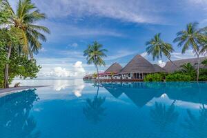 magnifique au bord de la piscine et le coucher du soleil ciel. luxueux tropical plage paysage, plate-forme chaises et chaises longues et l'eau réflexion. plage nager bassin à le coucher du soleil avec réflexion de paume des arbres, tropical paysage photo