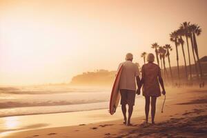 Sénior couple en portant planche de surf sur plage sur le coucher du soleil photo