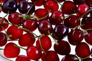 une proche en haut de une bol de cerises photo