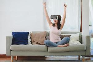 femme asiatique excitée dans un casque vr levant les deux mains photo