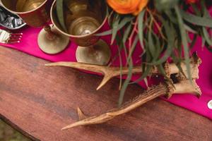 table en bois décorée avec des fleurs, des bougies, des ustensiles photo