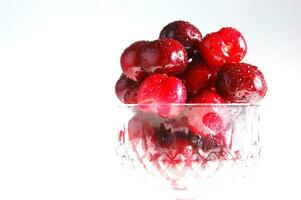 une proche en haut de une bol de cerises photo