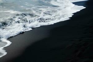 noir le sable plage dans Islande avec vagues s'écraser sur le noir sable, silhouettes de touristes profiter le noir le sable plage et océan vagues, ai généré photo