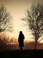 silhouette de une solitaire femme des stands seul photo
