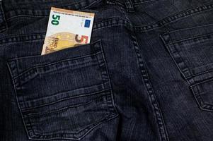 50 euros qui sortent de la poche du jean photo