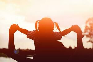 une silhouette de une content Jeune mère harmonieux famille en plein air. en riant et en jouant dans le été sur le le coucher du soleil background.sstkhome photo