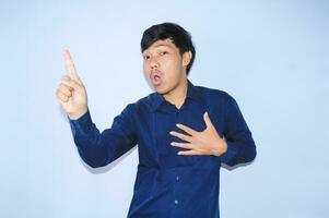 étonné Jeune asiatique homme avec sensationnel visage expression montrer du doigt doigt en haut avec réussi idée à campagne cœur maladie la prévention photo