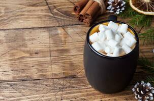 chaud Chocolat avec guimauve cannelle des bâtons, anis, des noisettes sur en bois arrière-plan, Noël concept photo