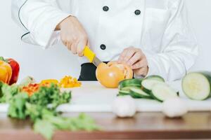 chef femme mains Coupe tomates et légumes, proche en haut de chef femme mains Coupe tomates et légumes, chef mains en train de préparer et Coupe des légumes photo