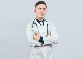 portrait de Beau médecin avec bras franchi isolé. Latin médecin avec franchi bras sur blanc Contexte. photo