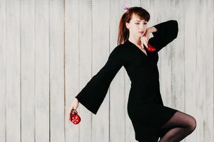 une jeune danseuse en robe noire, avec castagnettes, fond clair photo