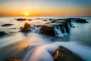 une magnifique le coucher du soleil plus de le océan avec rochers et l'eau. généré par ai photo