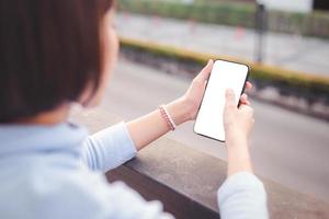 jeune femme utilisant un smartphone avec une maquette d'écran vierge photo