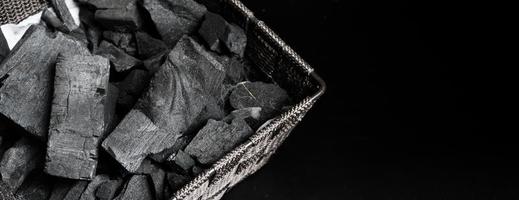 charbon de bois noir sur sol texturé noir photo