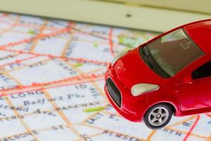 Photo horizontale de jouet voiture rouge gros plan sur la carte dans l'écran de la tablette