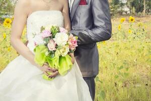 beau bouquet de différentes couleurs dans les mains de la mariée. photo