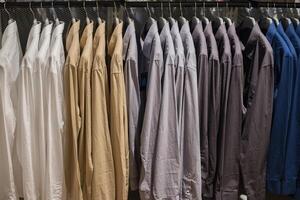 chemise accrochée au rail au magasin de vêtements. photo