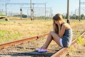 dérangé adolescent fille séance sur rail Piste dans campagne photo