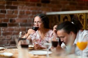 femme ayant une verre de du vin à famille fête dans restaurant photo