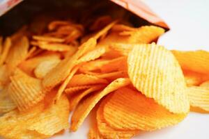 croustilles de pommes de terre dans un sac ouvert, délicieux assaisonnement pour barbecue épicé pour les frites, collations frites en tranches fines de restauration rapide. photo