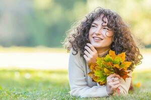 Jeune femme plein de émotions de l'automne saison. fille avec une dentaire un appareil dentaire et frisé cheveux photo