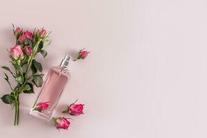 une élégant bouteille de cosmétique vaporisateur, parfum pour femmes sur une délicat Contexte parmi petit boutons de rose. une copie espace. présentation de le fragrance. photo