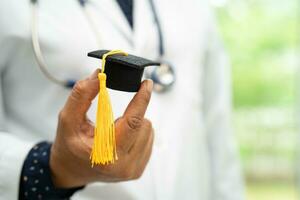 étude de médecin asiatique apprendre avec un chapeau d'écart de graduation dans la salle d'hôpital, concept de médecine d'éducation de génie brillant intelligent. photo