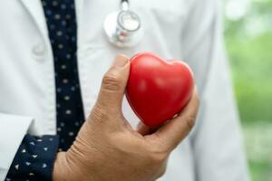 médecin tenant un coeur rouge dans la salle d'hôpital, concept médical solide et sain. photo