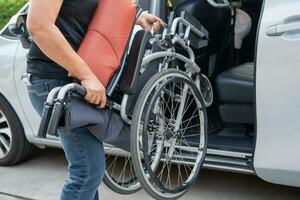 asiatique invalidité femme sur fauteuil roulant avoir dans sa voiture, accessibilité concept. photo